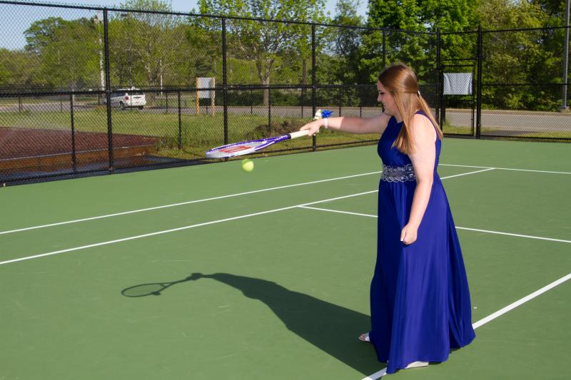 Girls tennis team member Elizabeth Griffith plays on the court in her dress before the promenade. BY ANDREW W. GRIFFITH